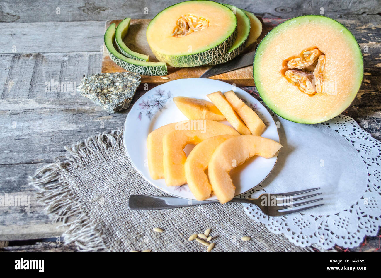 Runde Scheiben Melone auf ein Schneidebrett Stockfoto