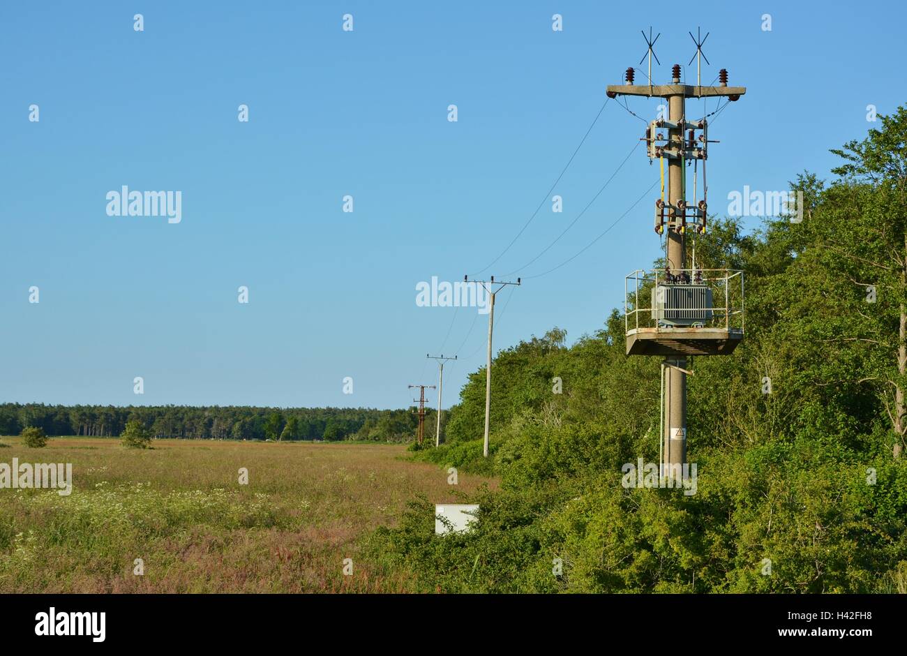 Industrielle Kraft Hochspannungskabel gegen blauen Himmel Stockfoto