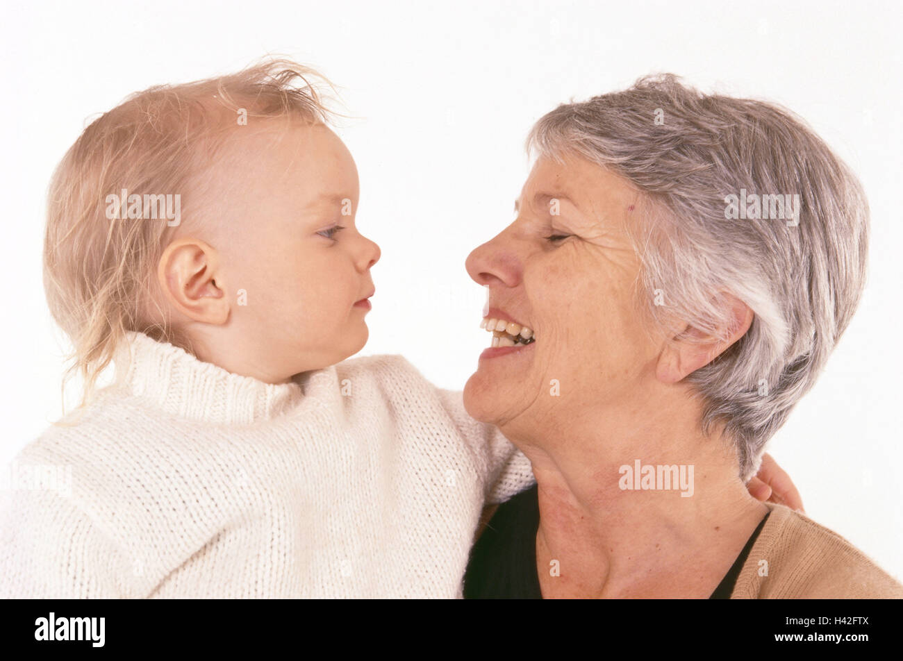 Großmutter, Enkelin, Lächeln, Blickkontakt, Profil, Frau, 60 Jahre, grauhaarige, Kind, Kleinkind, Enkelin, Mädchen, 2 Jahre, Umarmung, Vertrauen, Nähe, Zuneigung, glücklich, Generationen, zwei Liebe, lachen Stockfoto