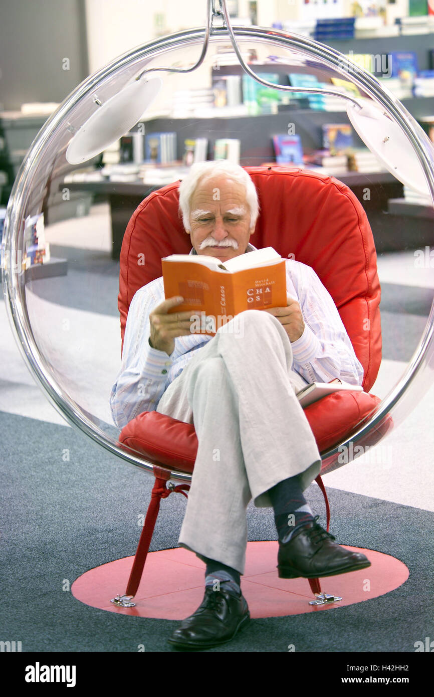 Bibliothek, Senior, Kugel-Stuhl, sitzen, lesen Buch, durchsuchen Buchhandlung, Stadtbibliothek, Kugel Sessel, Stuhl, Sessel, Mann, Rentner, 60-70 Jahre, Rentenalter, Alter Mensch, Freizeit, Auszeit, Bücherwurm, Interesse, Informationen, Weiterbildung