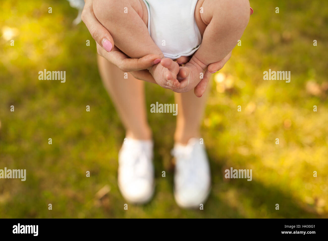 Mutter ihr Baby in den Händen halten Stockfoto