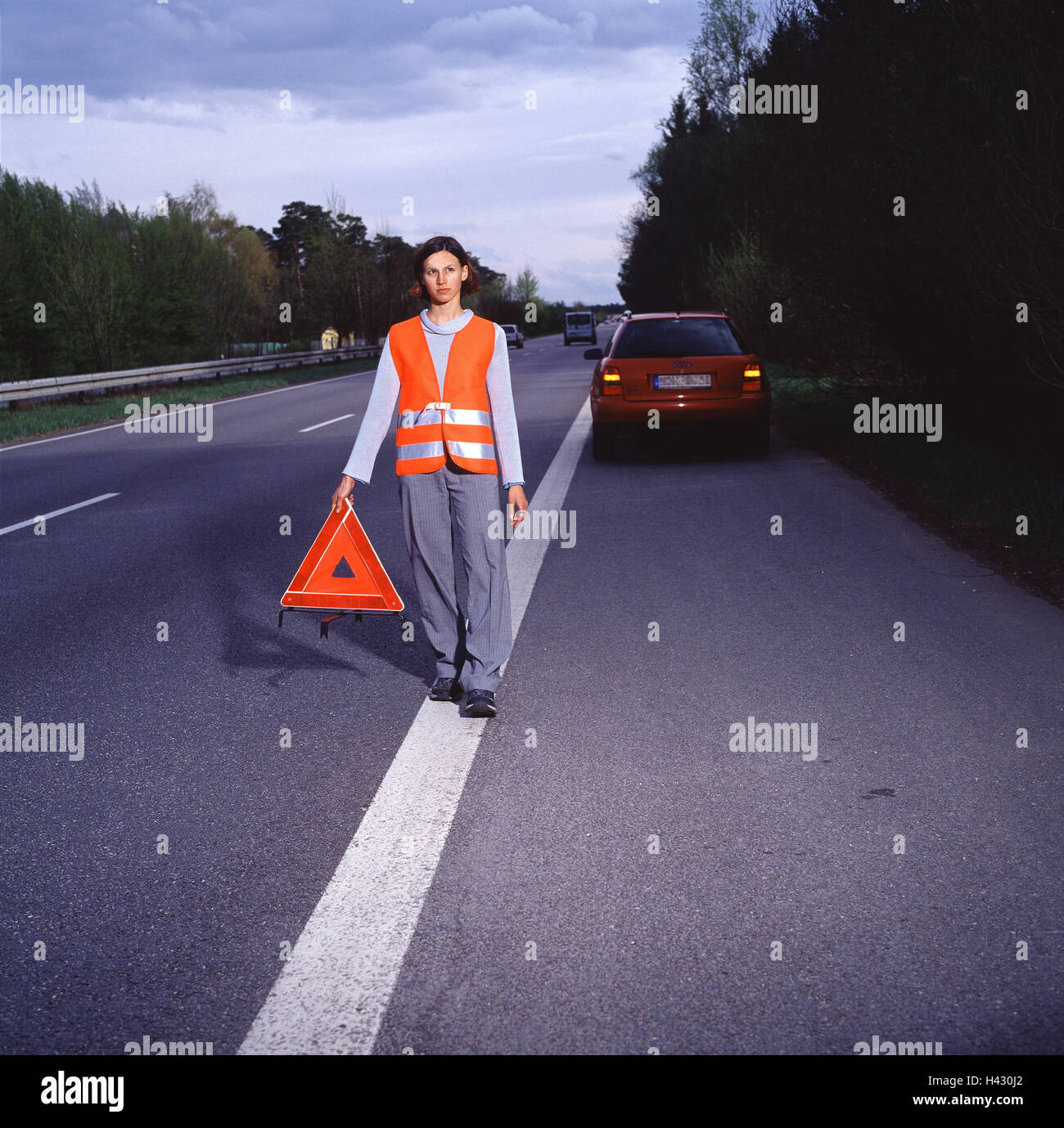 Autobahn, Standstreifen, Frau, Notfall Straßenschild, platzieren Sie Sicherheitsweste, Fahrzeug, Geschäft, Dämmerung Straße, Autobahn, mehrspurigen, Aufschlüsselung, Autobreakdown, Unfall, Unfall Maßnahme, die Unfallstelle, Gefahr, Gefahr, hedging, Warnung, Warnweste, Pflicht, Ordnung, Warnung West Pflicht, Sicherheitsmaßnahme Stockfoto