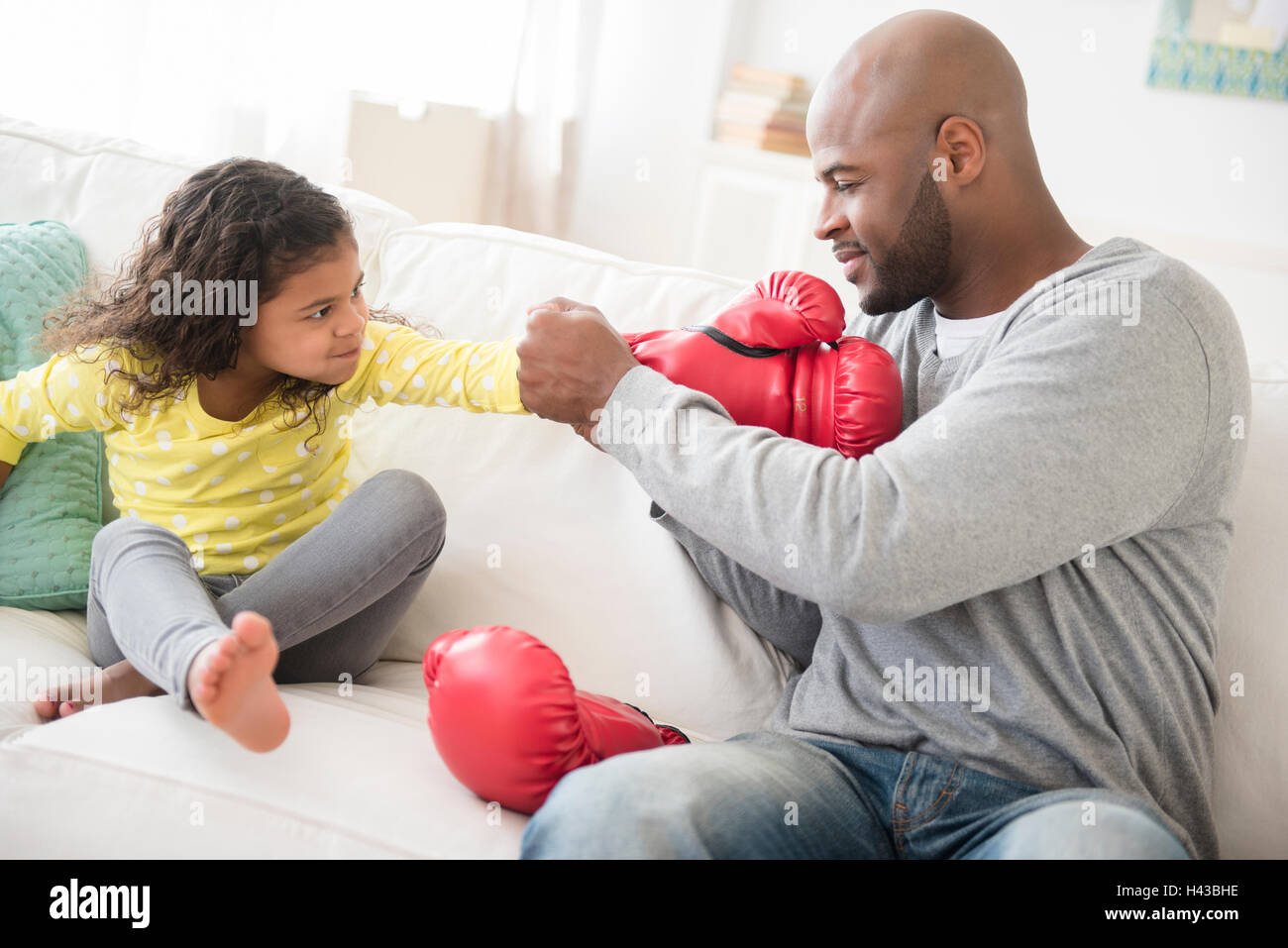 Vater helfende Tochter mit Boxhandschuhen Stockfoto