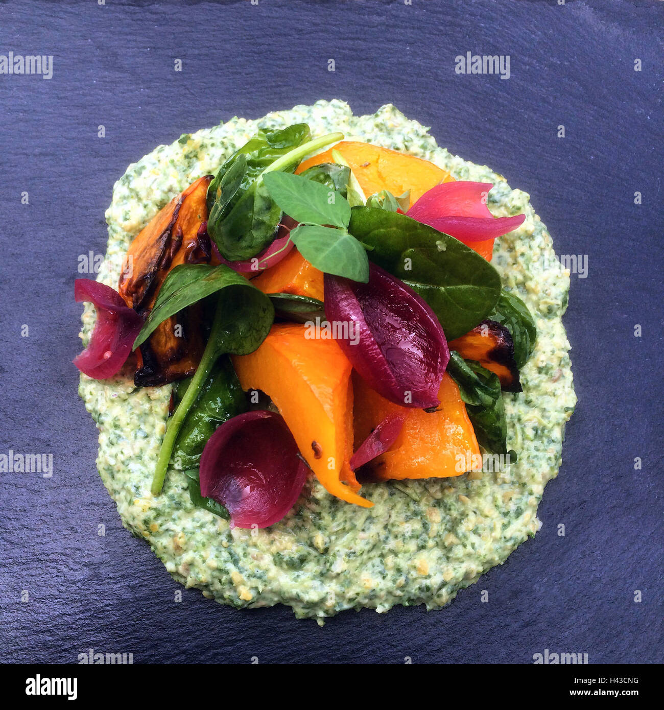 Spinat-Humus mit Kürbis, Spinat und rote Zwiebel Stockfoto