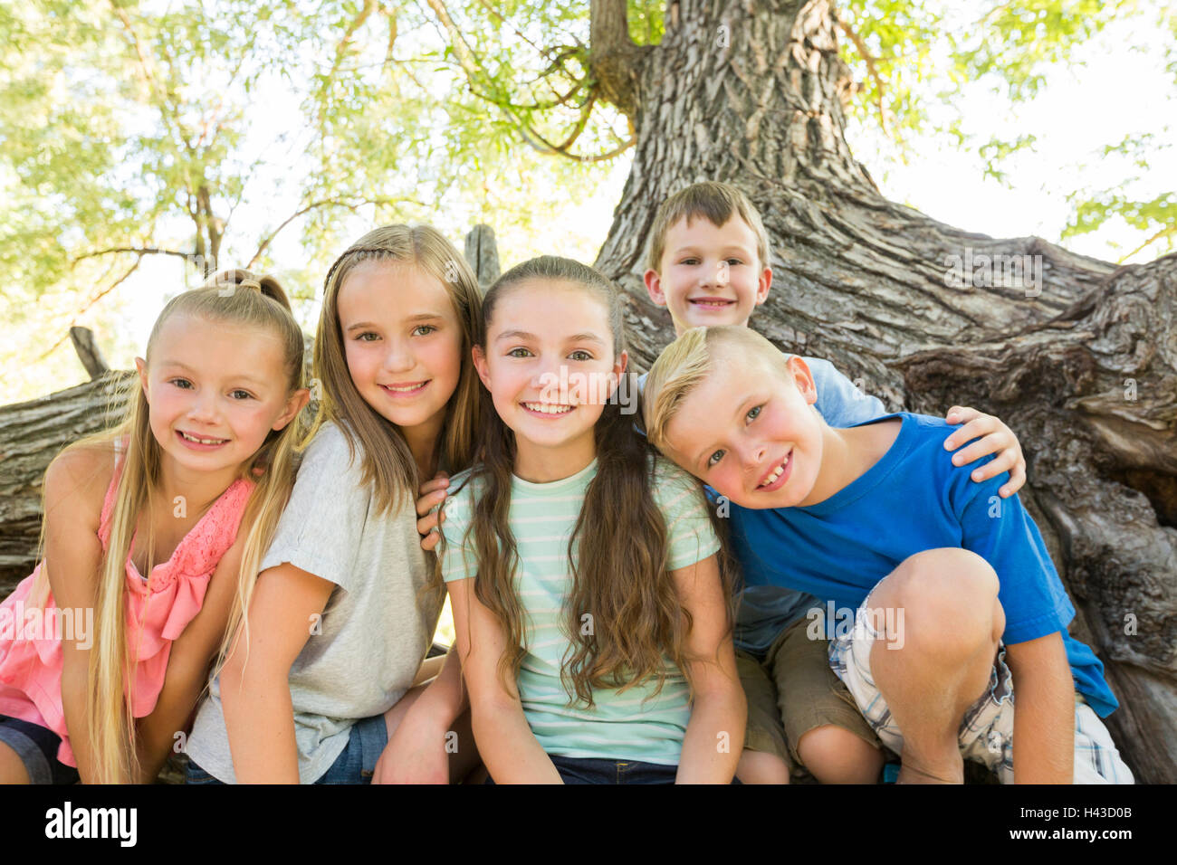 Kaukasischen jungen und Mädchen posiert in der Nähe von Baum Stockfoto