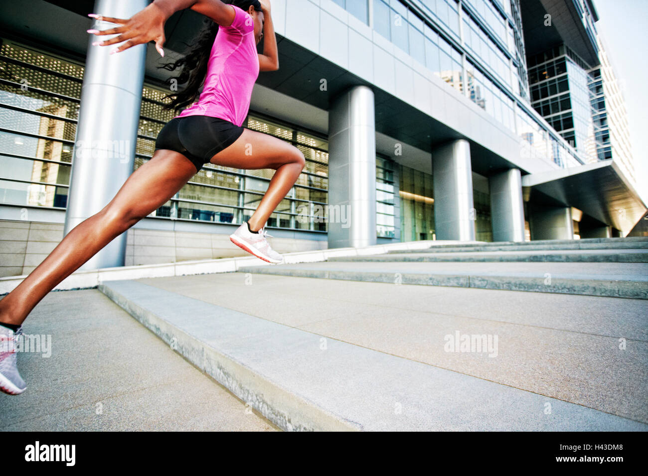 Schwarze Frau laufen und springen auf Stadt-Treppe Stockfoto
