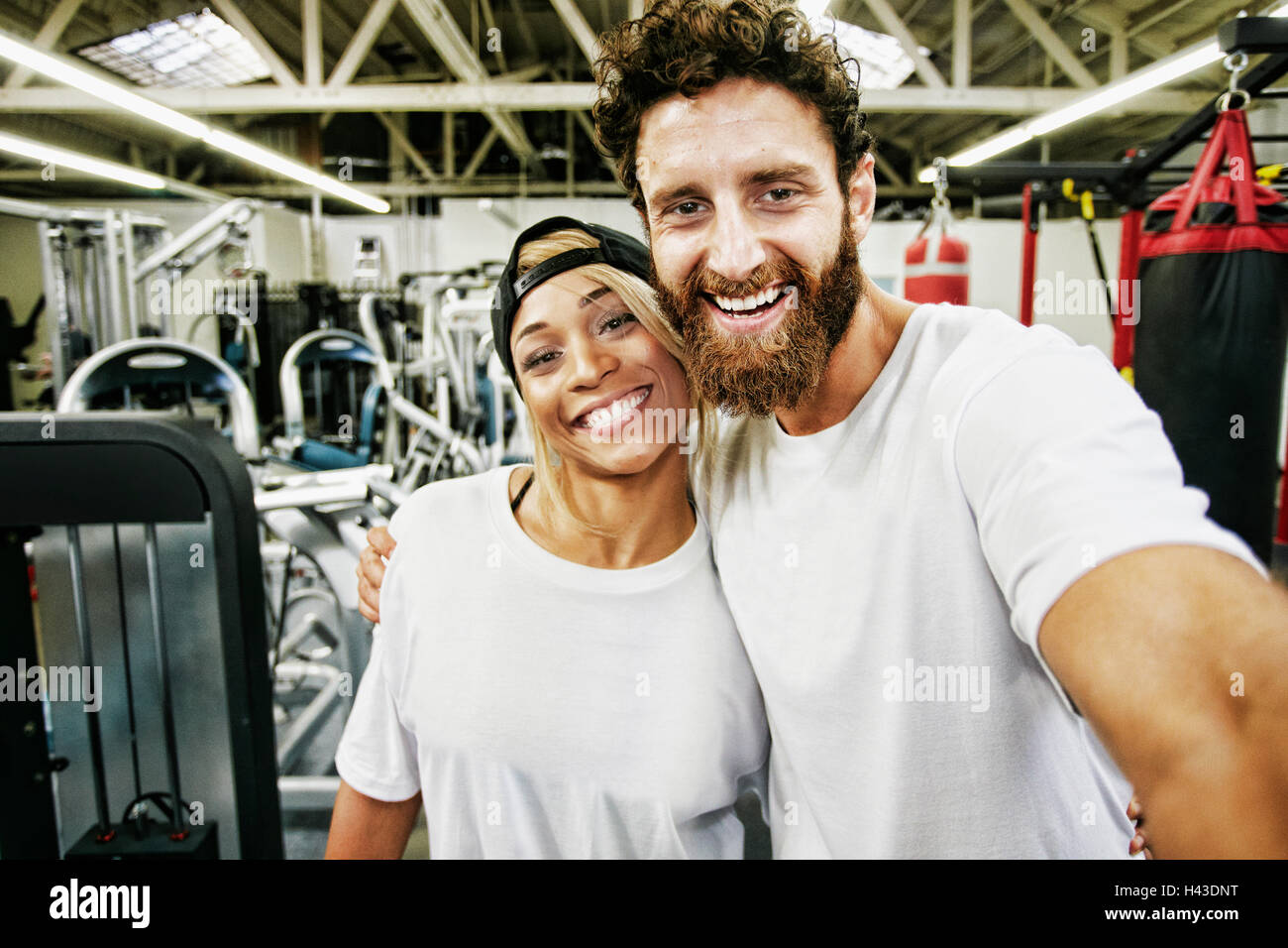 Gemischte Rennen Mann Paar posieren für Handy Selfie im gymnasium Stockfoto