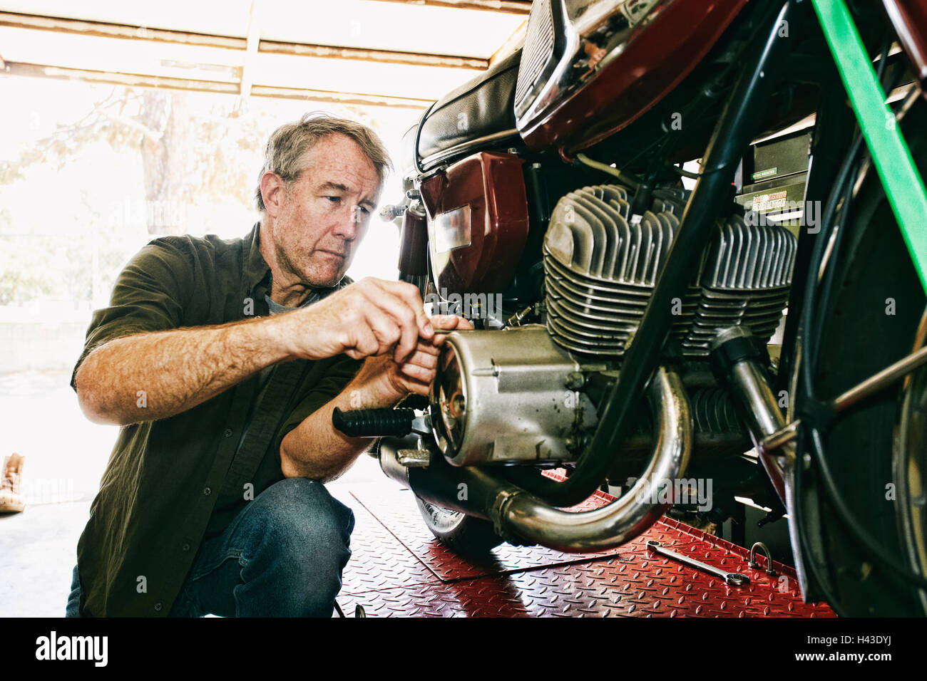 Kaukasischen Mann Reparatur Motorrad in garage Stockfoto