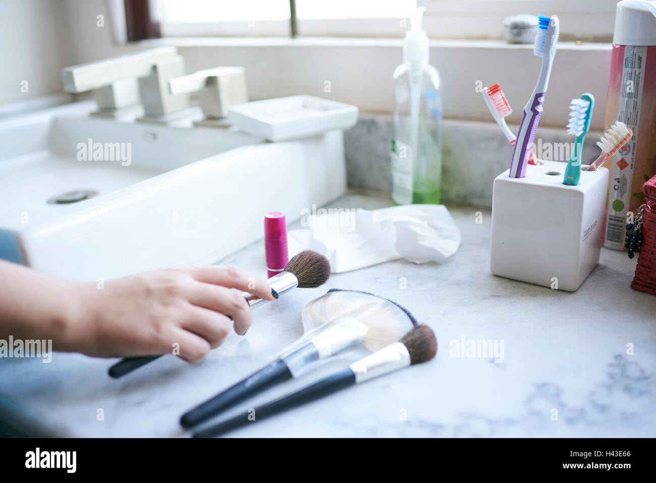 Hand des Hispanic Frau hält Make-up Pinsel Stockfoto