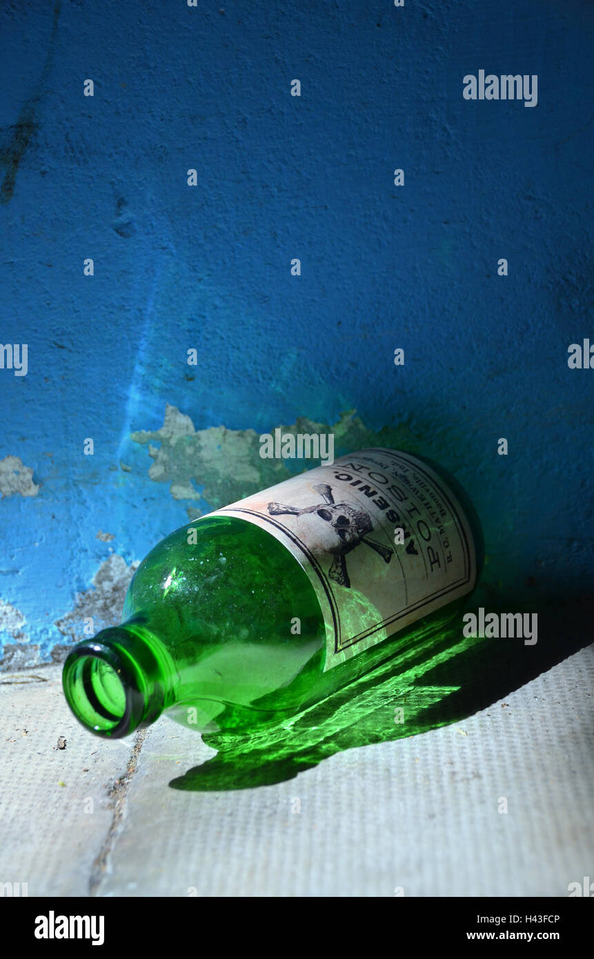 Eine alte grüne Glasflasche mit Arsen Poison beschriftet und ein Schädel und Knochen Zeichen auf dem Boden liegt. Stockfoto