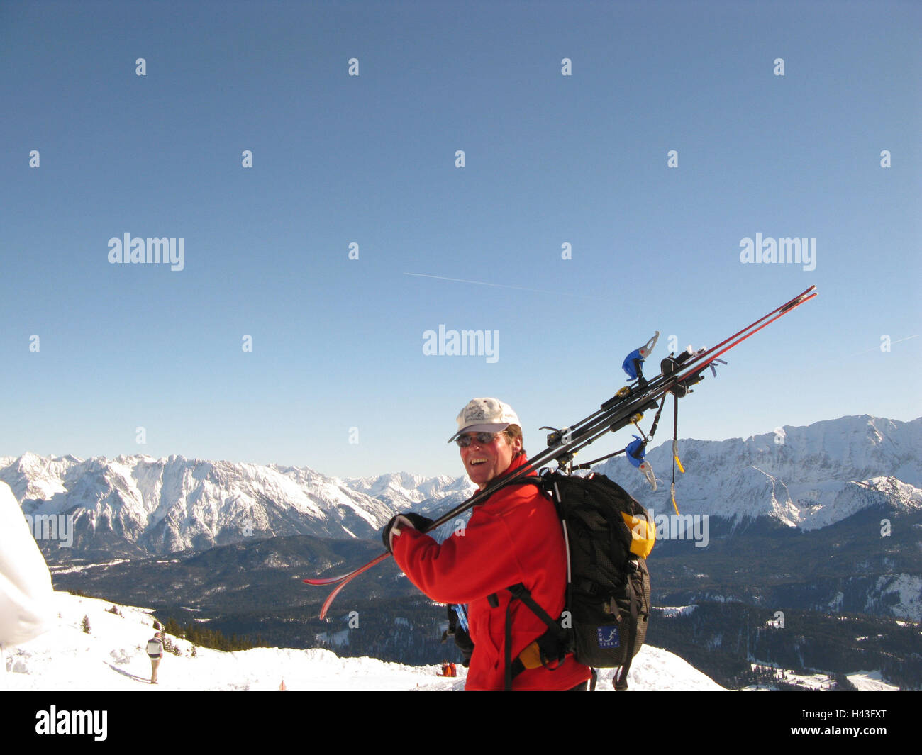 Deutschland, Oberbayern, Garmisch-Partenkirchen, Taumelns, Skifahrer, anzeigen, Kamera, Lächeln, Berglandschaft, Bayern, Karwendelgebirges, Wettersteingebirge, Berge, Berge, Gebirge, Ansicht, Schnee, Winter, Sonne, Himmel, blau, Mann, Person, Seitenansicht, Sonnenbrille, Baseball-Kappe, Kopfbedeckung, Rucksack, Ski, Skifahren, Hobby, Freizeit, Sport, Stockfoto