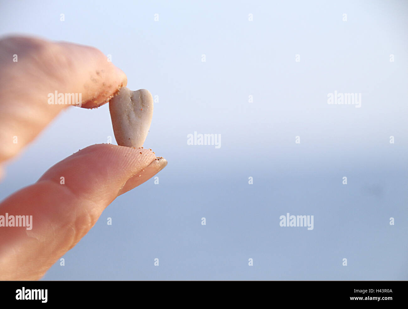 Hand, die einen herzförmigen Stein Stockfoto