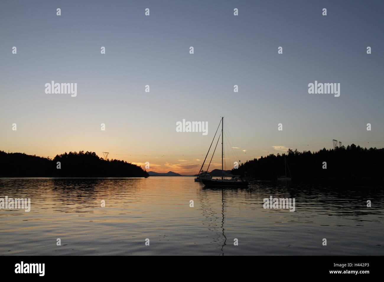 Montague Hafen bei Sonnenuntergang mit einem Segelboot im Hintergrund, Galiano Island, British Columbia Stockfoto