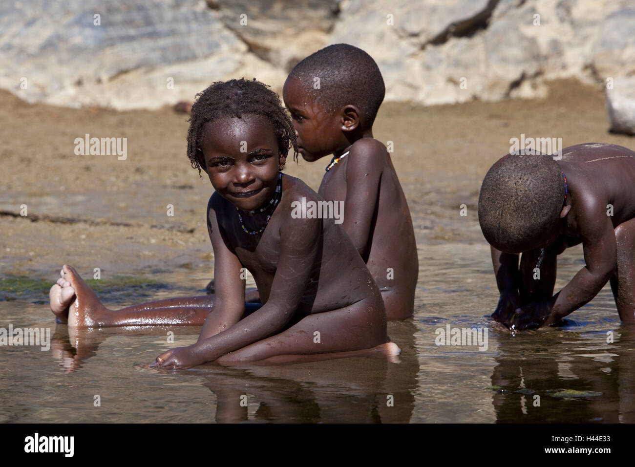 Afrika, Namibia, Namibia, Region Kunene, Kaokoveld, legen Puros, Stamm der Himba, einheimische, Kinder in der Nähe von Baden, Stockfoto