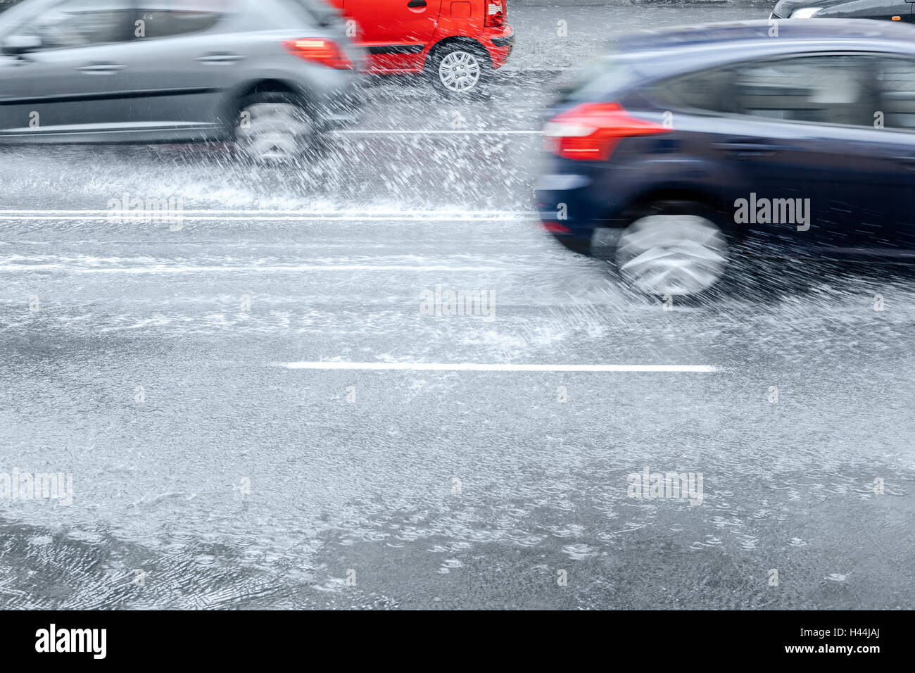 verschwommene Autofahren auf Stadt Straße mit Pfützen und Spritzer nass Stockfoto