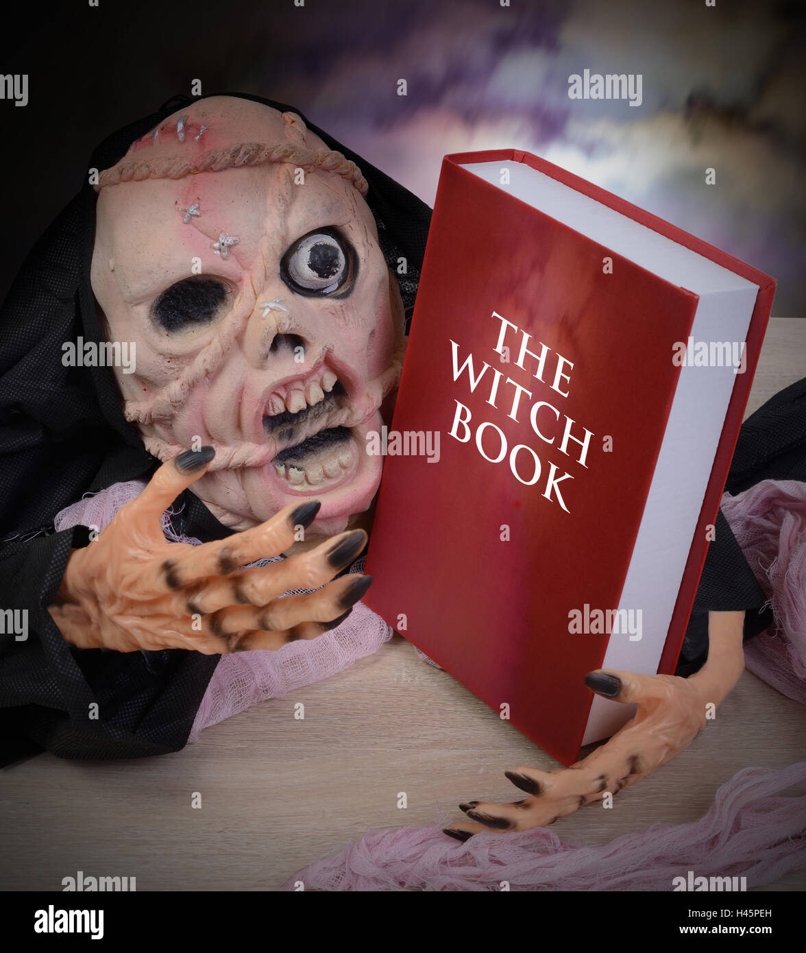 Geist mit Furcht einflössenden Gesicht hat eine rote Hexe-Buch in der hand. Stockfoto