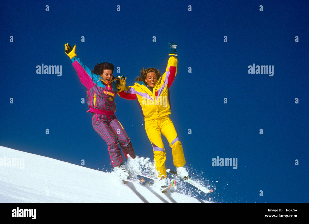 Zwei Mädchen zusammen auf Ski springen Stockfoto