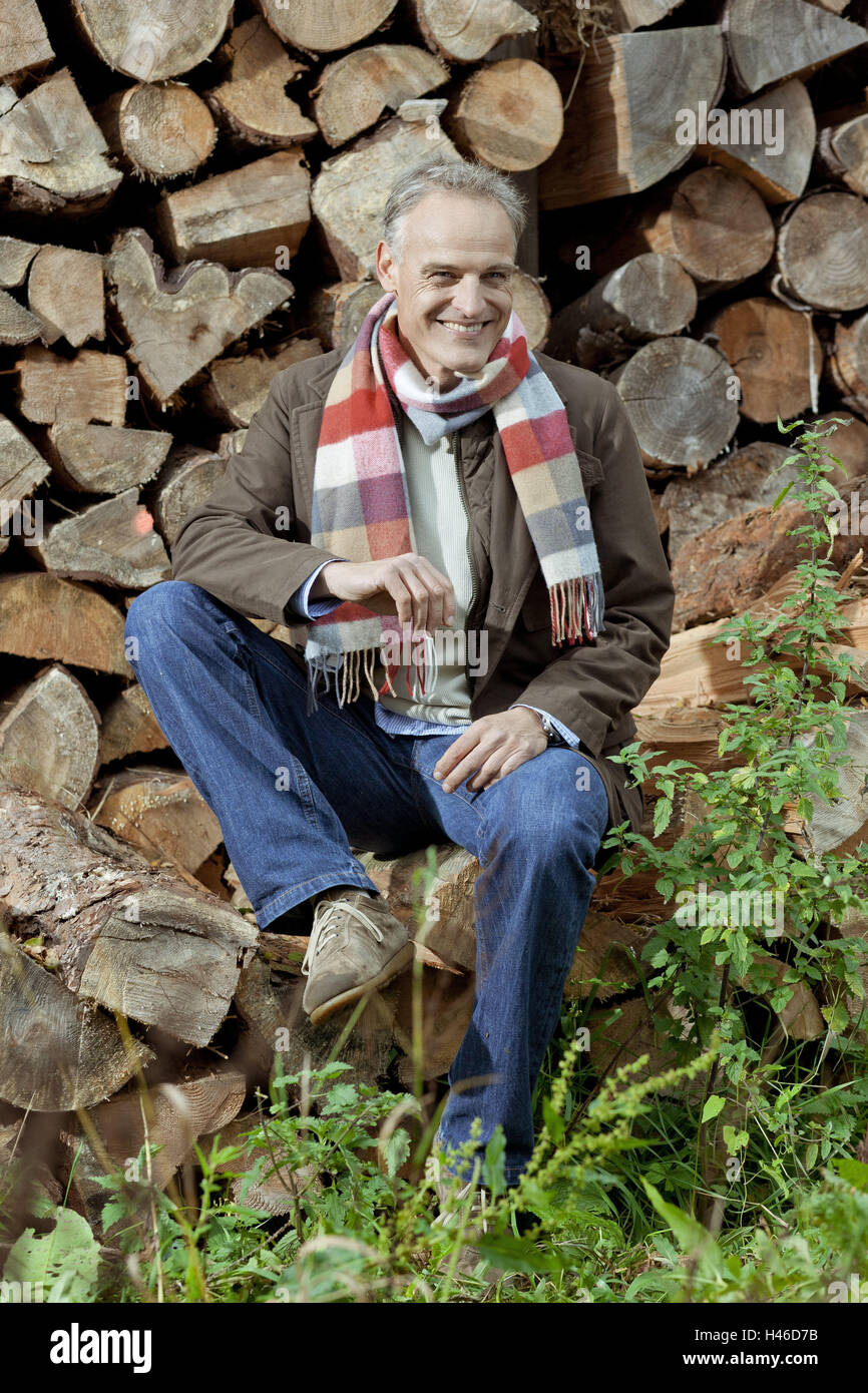 Holzpfähle, Mann, sitzen, sehen Sie Kamera, Lächeln, Stockfoto