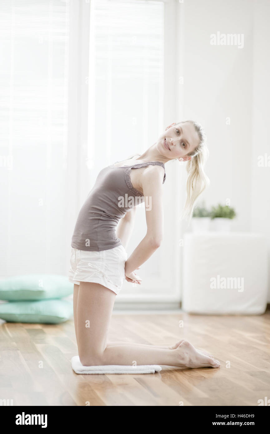 Junge Frau macht eine gymnastische Übung, Stockfoto