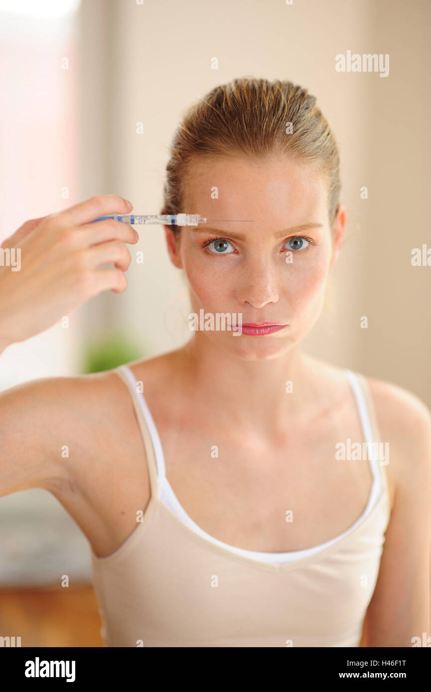 Junge Frau hält Spritze in der Hand, Stockfoto