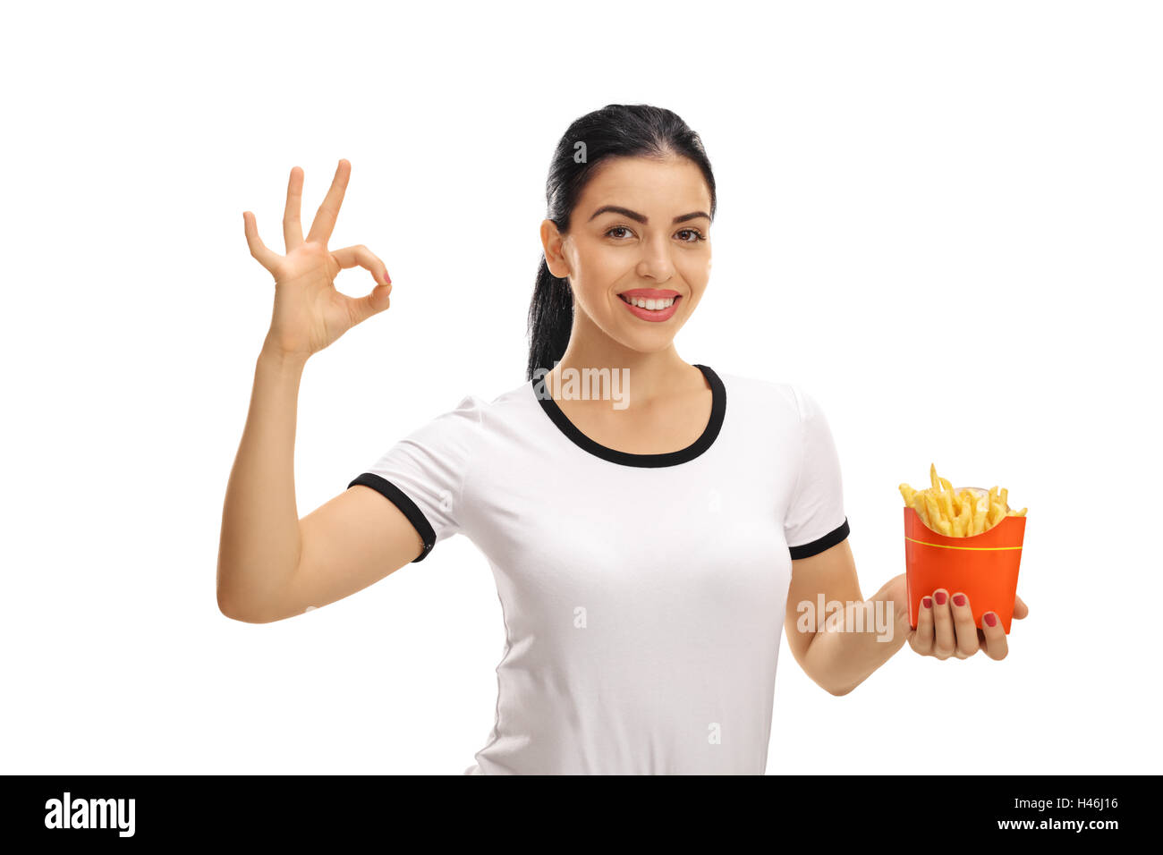 Glückliche Frau hält einen Beutel mit Pommes Frites und eine Ordnung Geste isoliert auf weißem Hintergrund Stockfoto
