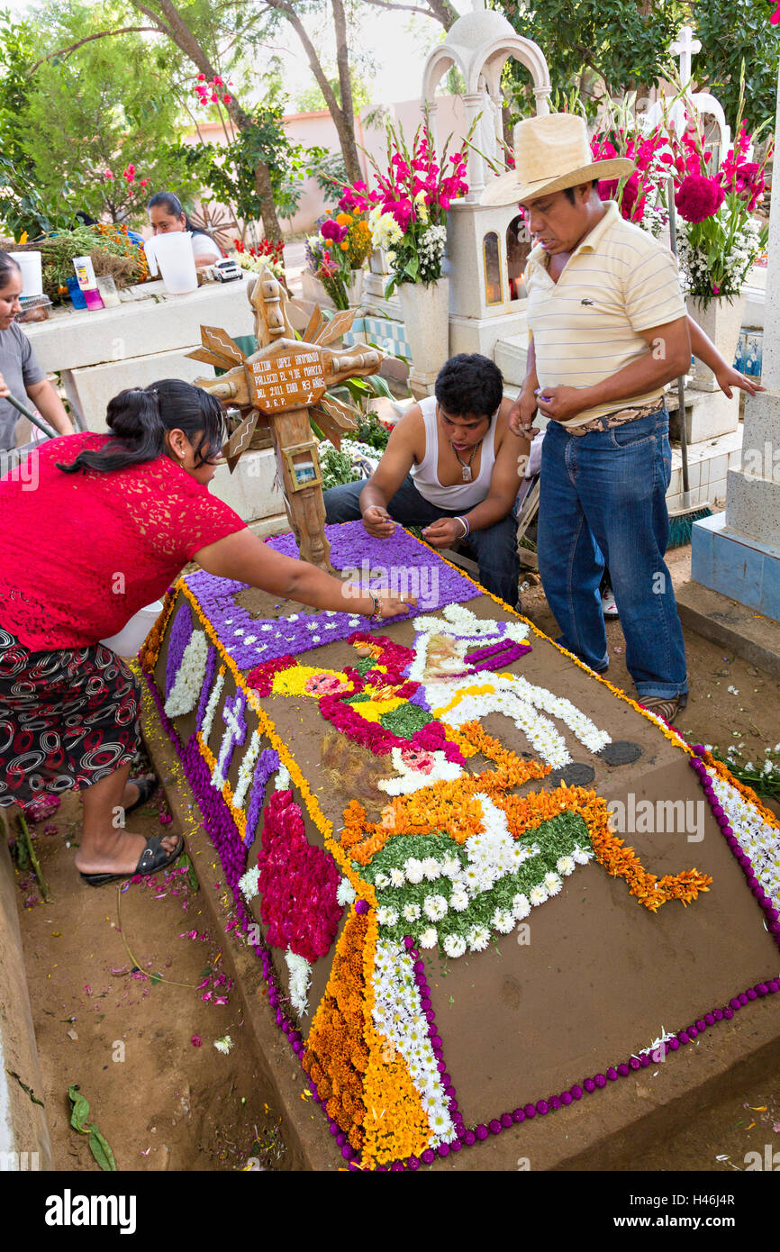 Menschen dekoriert ein Graves mit aufwendigen floralen Pedal Wandteppiche zu Ehren des Verstorbenen auf dem Friedhof San Antonino Castillo im Laufe des Tages von den Dead Festival bekannt als D'a de Muertos am 3. November 2013 in San Antonino Castillo Velasco, Oaxaca, Mexiko. Stockfoto