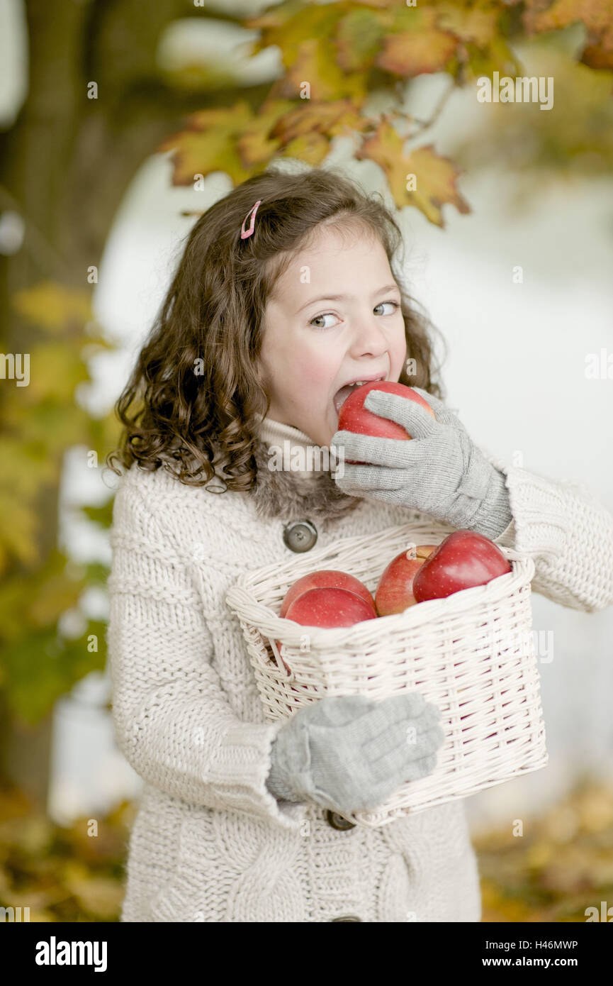 Kleines Mädchen beißt in einen Apfel, Stockfoto