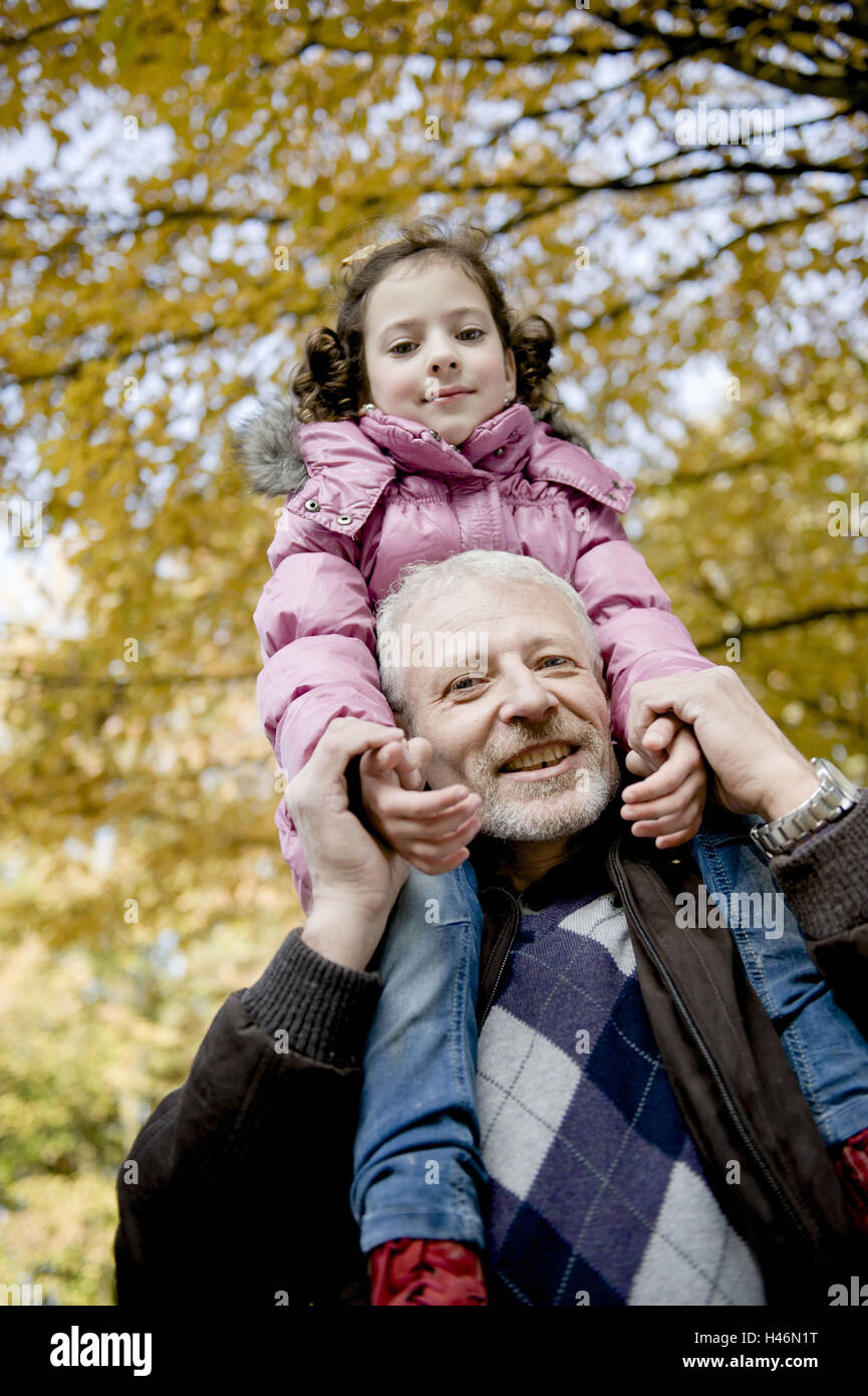 Großvater trägt Enkelin auf Schultern, Stockfoto