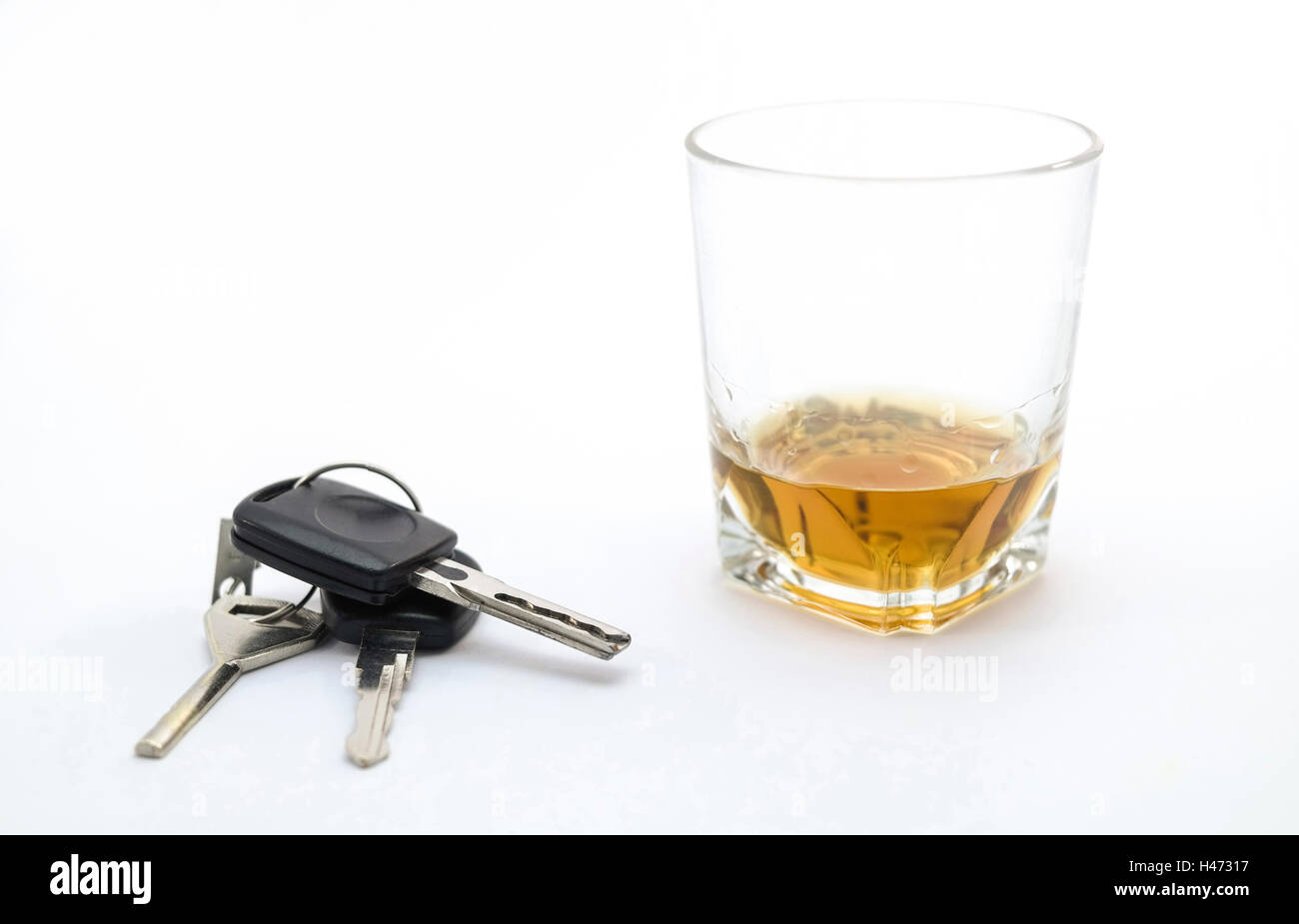 Autoschlüssel und ein Glas Alkohol Stockfoto