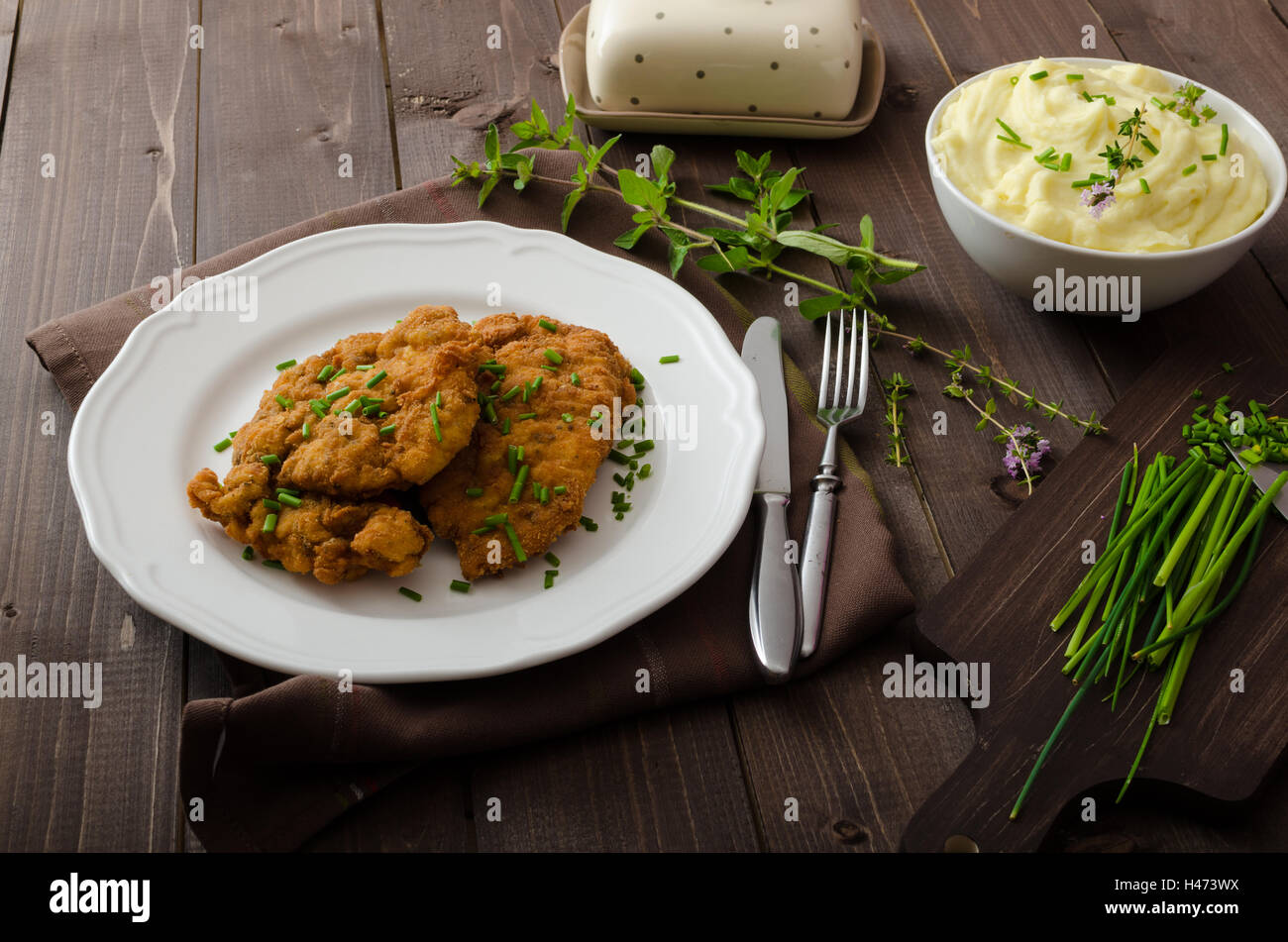Schnitzel mit Kräutern, Kartoffelpüree und Schnittlauch Stockfotografie ...
