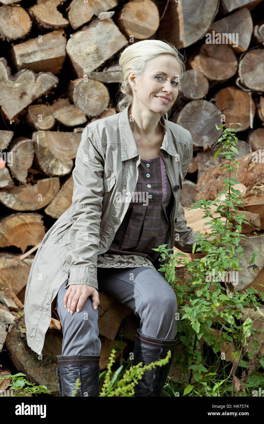 Holzpfähle, Frau, sitzen, sehen Sie Kamera, Lächeln, Stockfoto