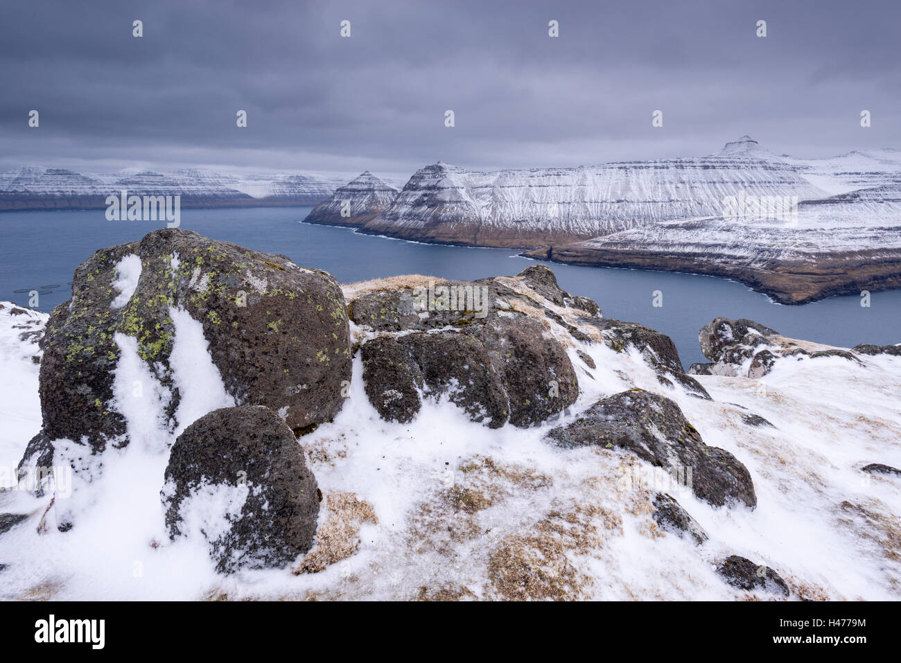 Dramatische schneebedeckte Berglandschaft über Funningsfjordur auf den Färöer Inseln, Dänemark. Winter (April) 2015. Stockfoto