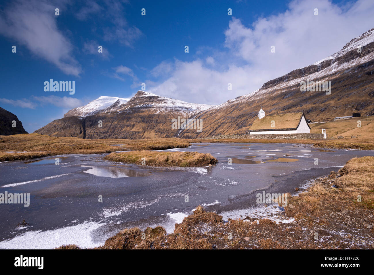 Spektakuläre Berglandschaft rund um Saksuns schönen Rasen überdacht Kirche, Streymoy, Färöer-Inseln, Dänemark, Europa. Winter (A Stockfoto