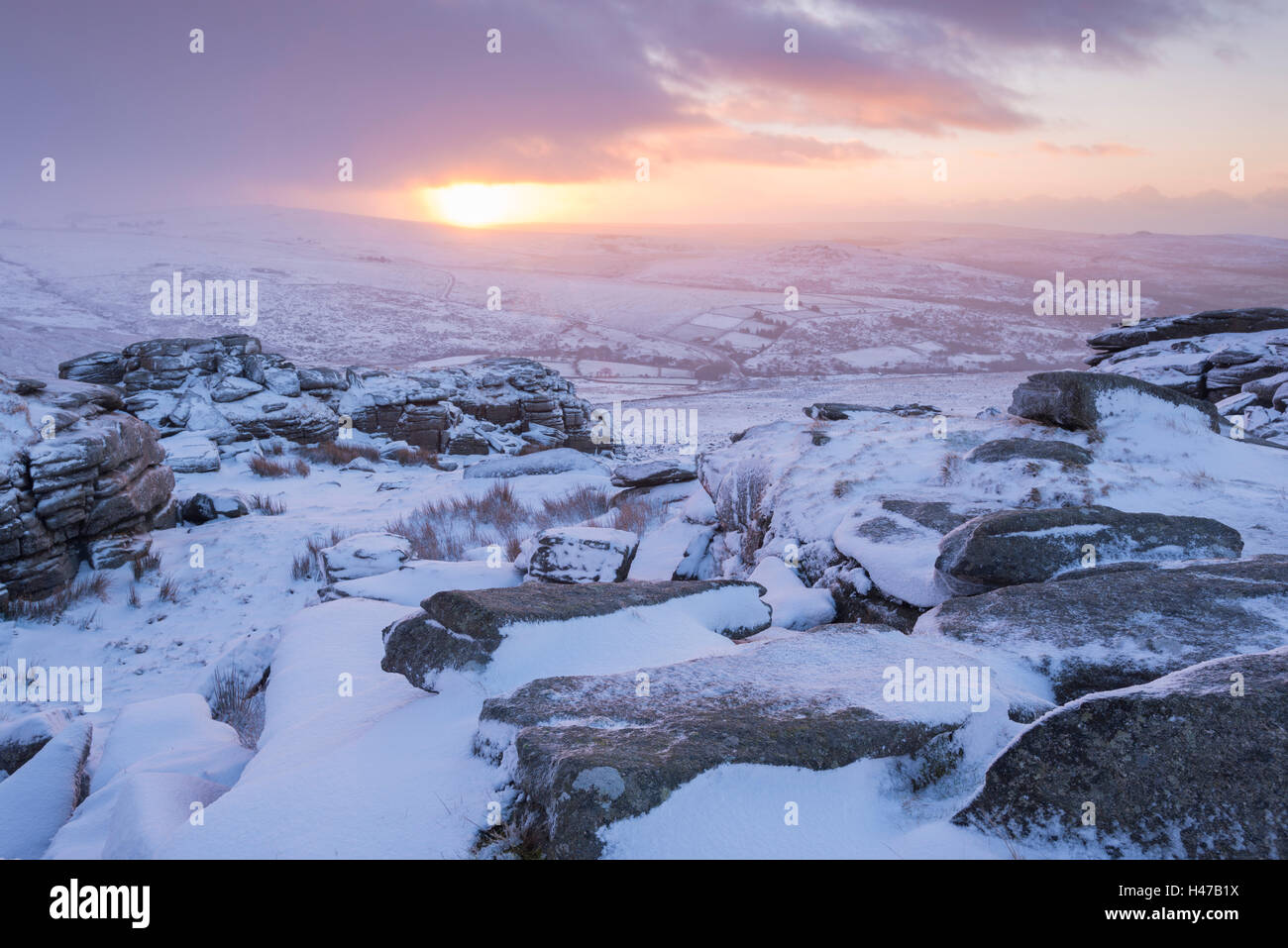 Schneebedeckte felsige Heidelandschaft bei Sonnenaufgang, große Grundnahrungsmittel Tor, Dartmoor, Devon, England. Winter (Januar) 2015. Stockfoto