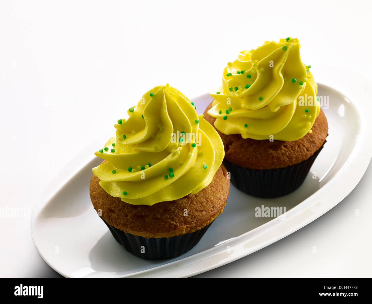 Cup Cakes, Bäckerei, Snack, isolierte Cup Cakes, gelbe Glasur, Erdbeerkuchen, Strawberry Cup Cake, Farben, Tasty, Mouthwatering, Stockfoto