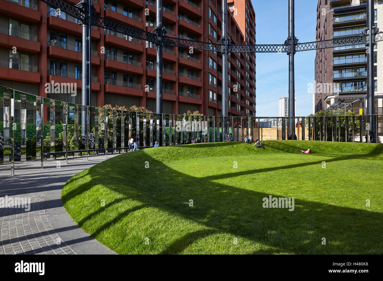Weiten Blick auf die Grünfläche innerhalb des Gas-Halter-Parks mit geschwungenen kreisförmige Rasen. Gasbehalter Nr. 8 Park, London, Vereinigtes Königreich. Architekt: Bell Phillips Architekten, 2016. Stockfoto