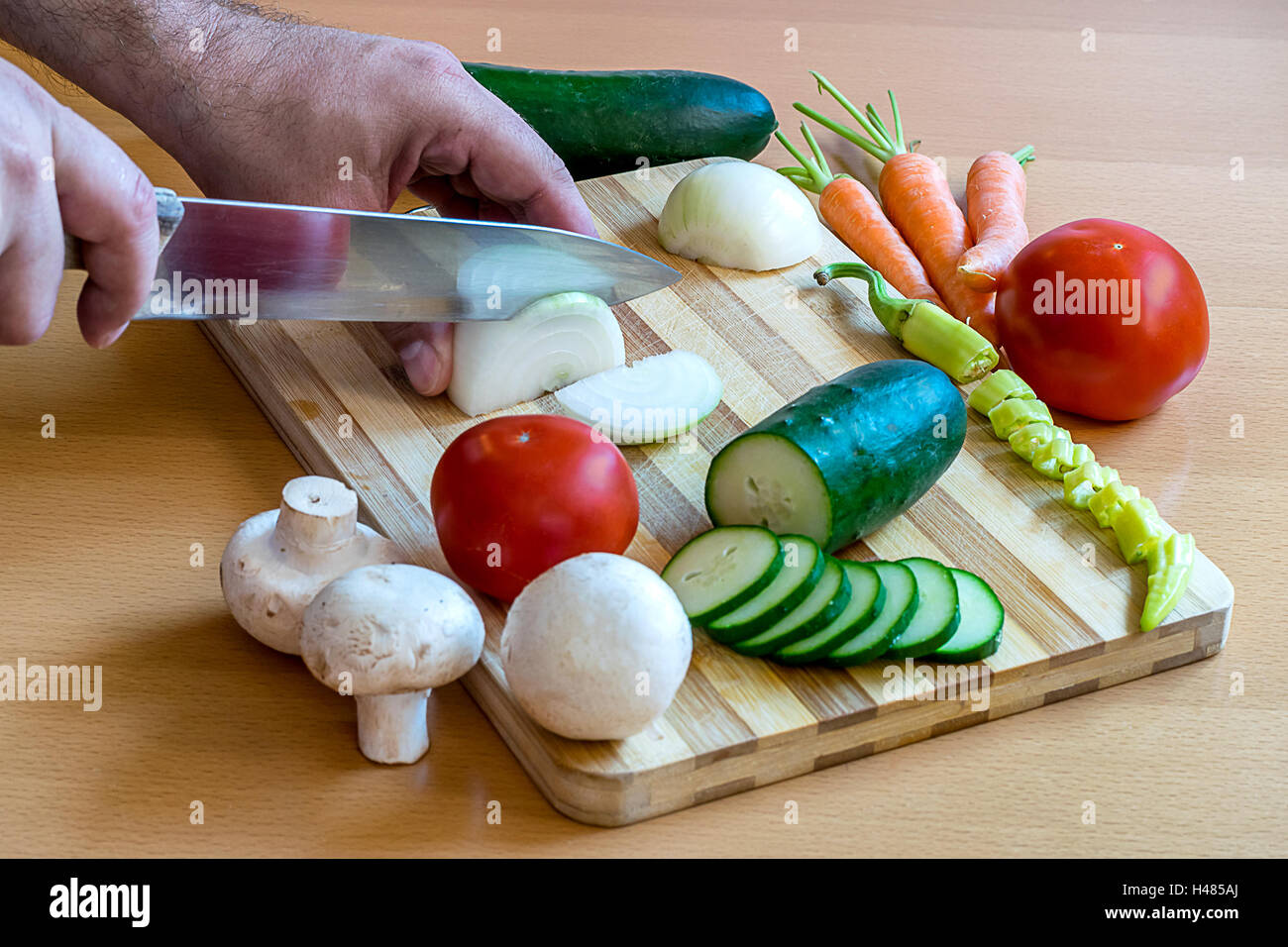 Mannes Hände schneiden von Gemüse auf ein Schneidebrett Stockfoto