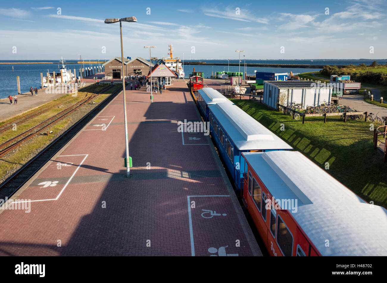 Schiffahrt Langeoog. Deutschland Deutschland. Der Zug ist neben dem Hafen Plattform während Passagiere rush auf die wartende Fähre vertäut am Steg. Dies ist das wichtigste Verkehrsmittel für Touristen zu besuchen und die Insel verlassen. Stockfoto