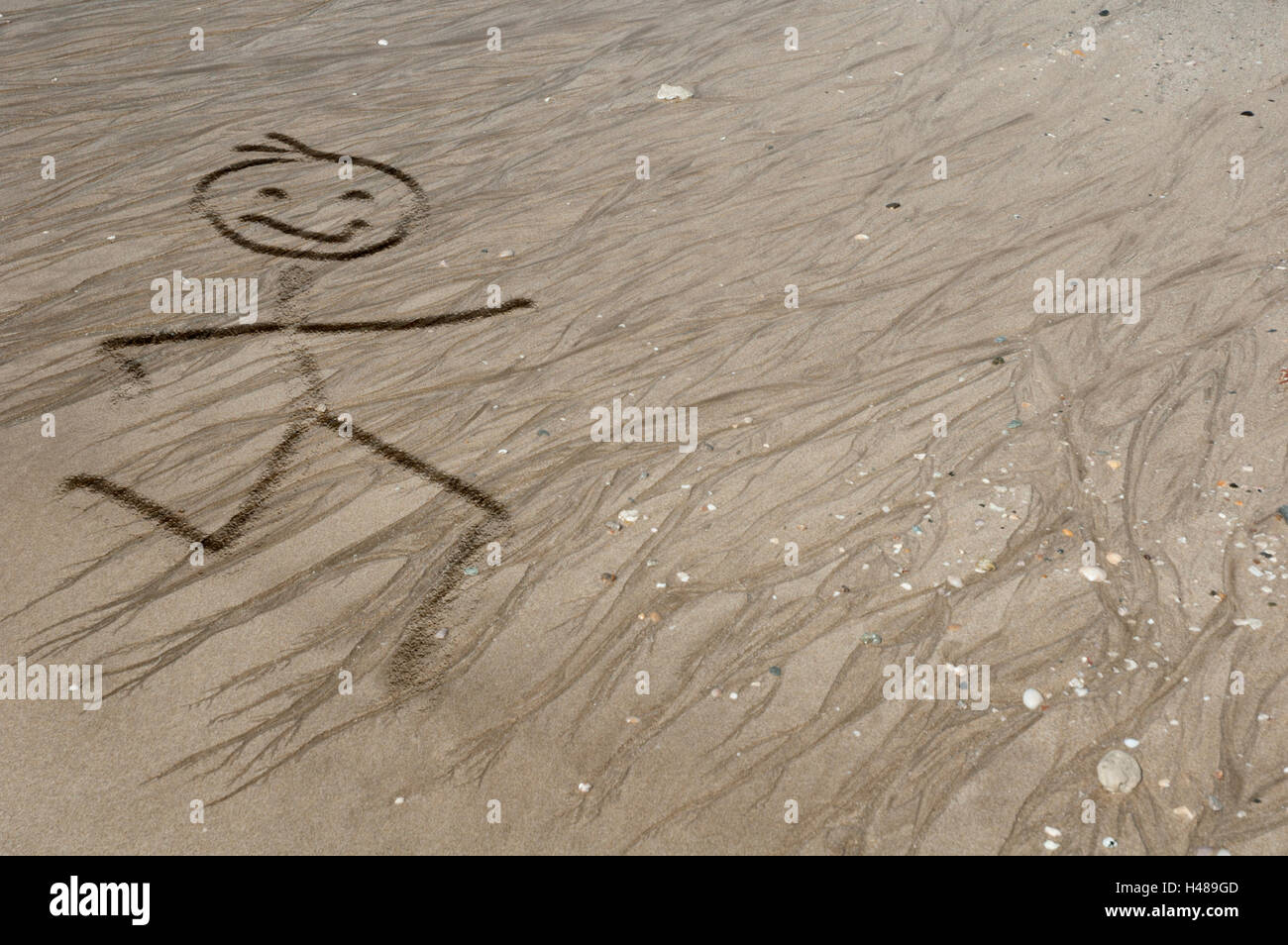 Stickman laufen auf dem sand Stockfoto