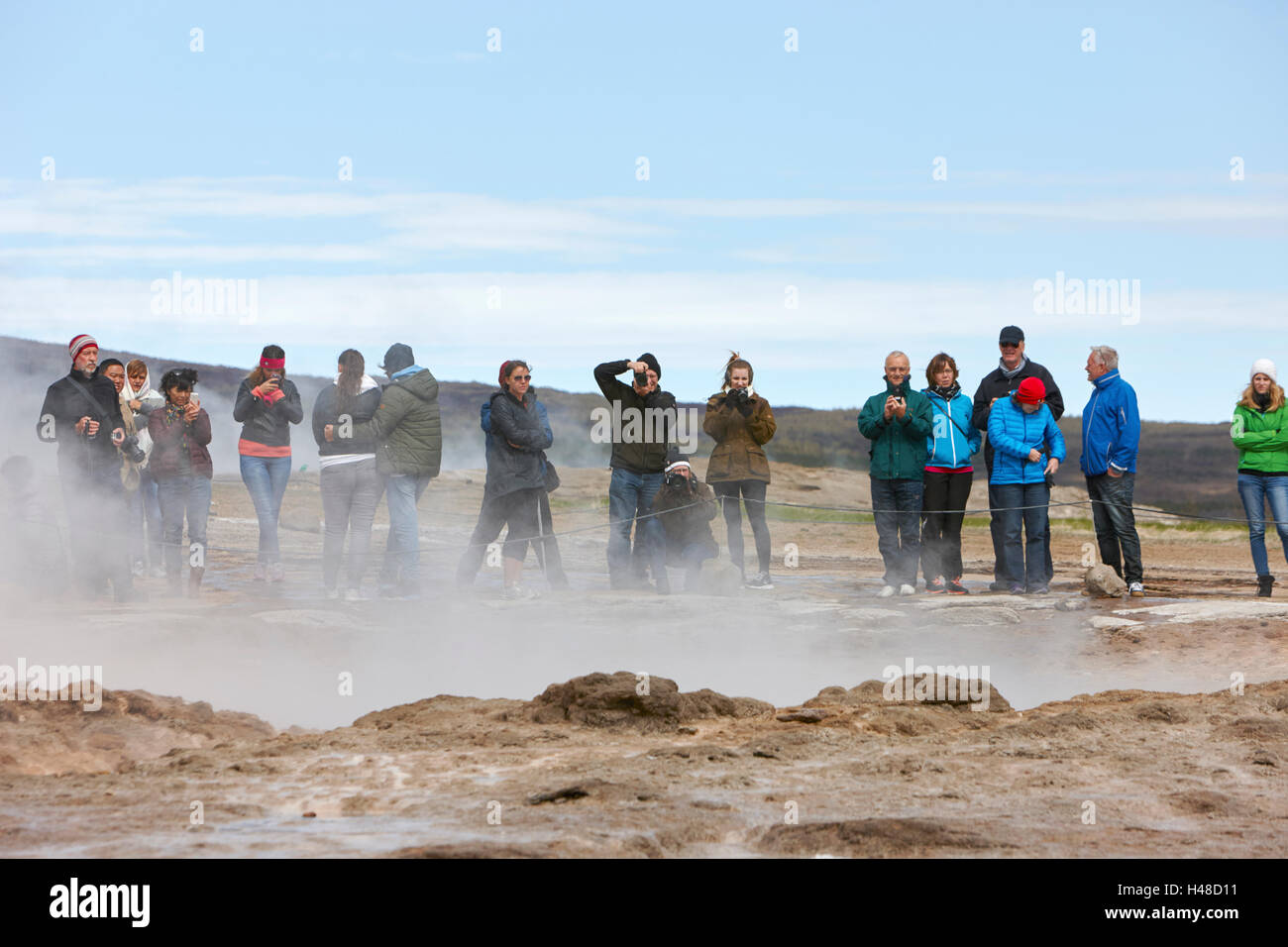 Touristen stehen herum und warten der Strokkur-Geysir zu Geysir Island ausbrechen Stockfoto