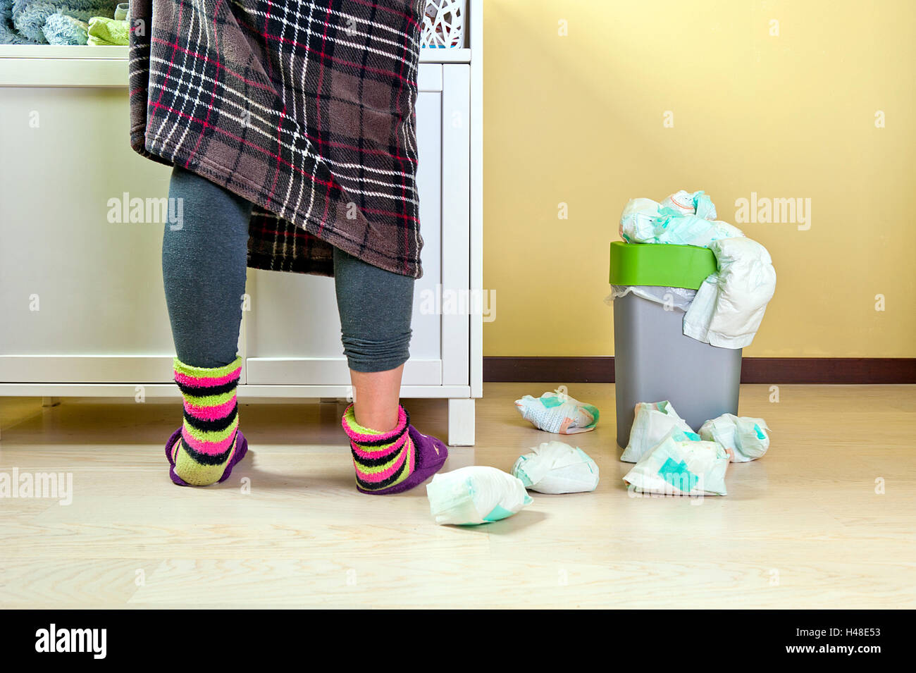 Frau im karierten Rock mit blauen Strumpfhosen und bunte Socken einige  Babys Windeln gebrauchten in einem Abfall Eimer gelegt und Stockfotografie  - Alamy