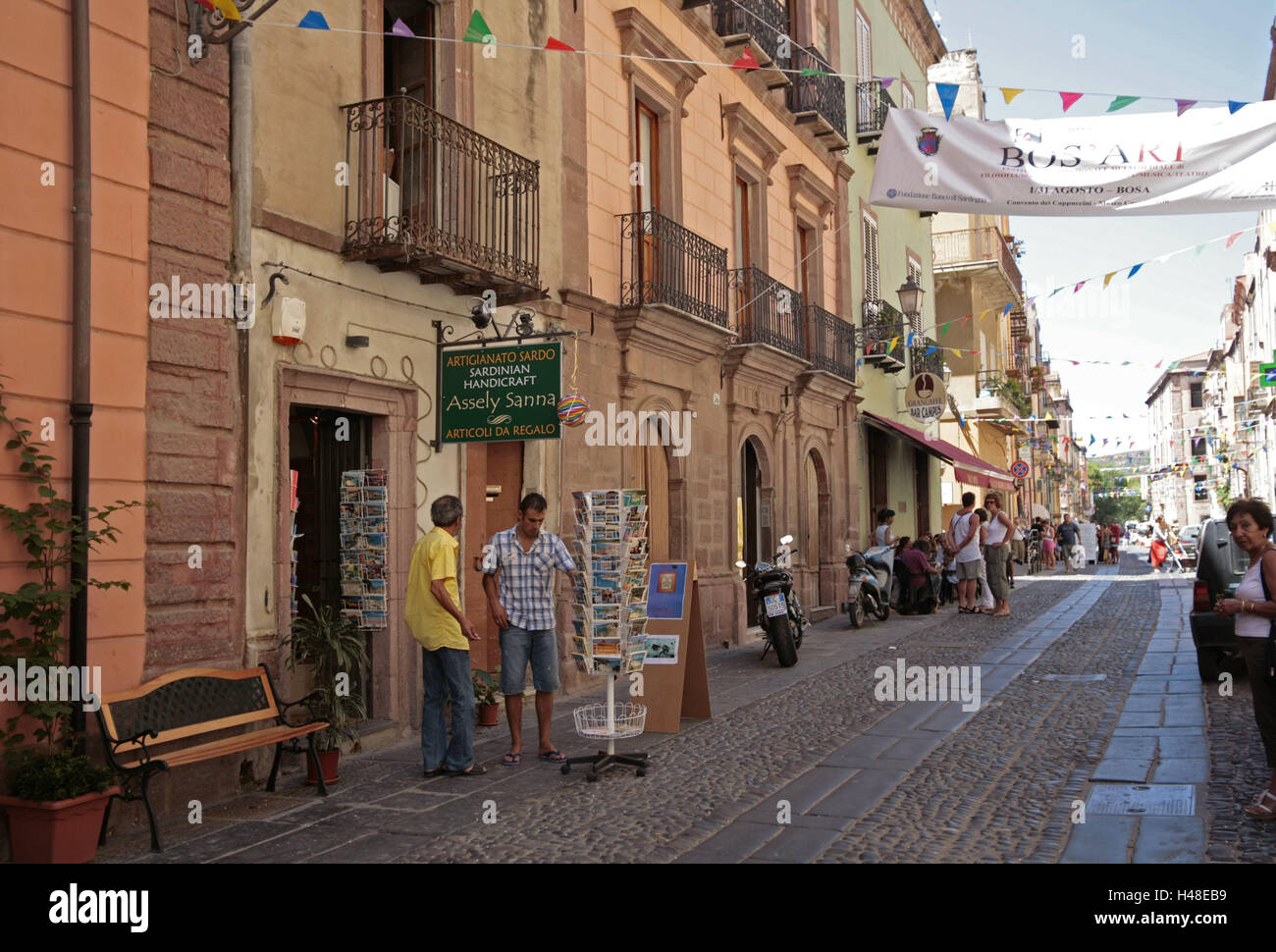 Italien, Sardinien, Bosa, Altstadt, Häuser, Geschäfte, Touristen, kein Modell loslassen, Europa, Insel, Reiseziel, Stadt, Gebäude, Architektur, Wohnhäuser, Fassaden, Terrasse, Geschäfte, Postkarten, Menschen, Tourismus, außerhalb, Anhänger, Girlanden, Stockfoto