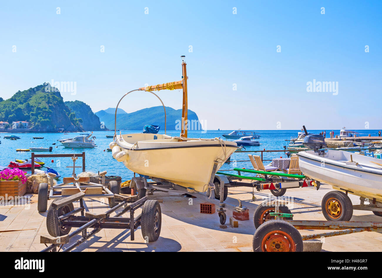 Das kleine Fischerboot steht auf dem Bootsanhänger am Ufer des kleinen Hafens in Petrovac, Montenegro Stockfoto