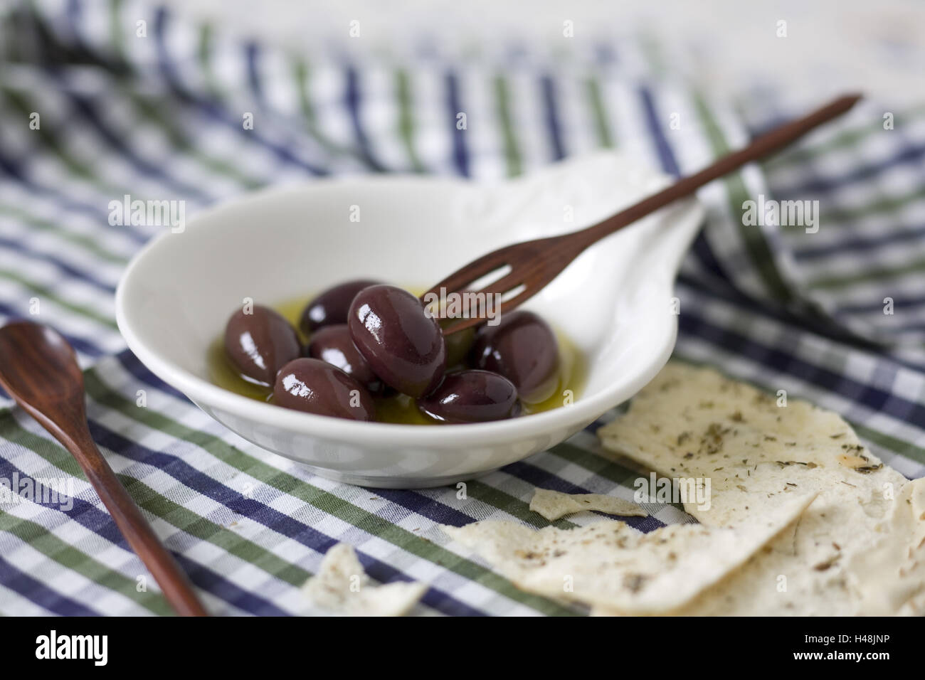 Olive gewölbte Platten auf Blau-Grün-Weiß-Kariertem Stoff, Stockfoto