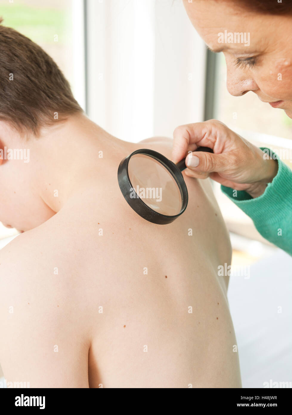 Jugendlicher wird von einem Dermatologen untersucht, Stockfoto
