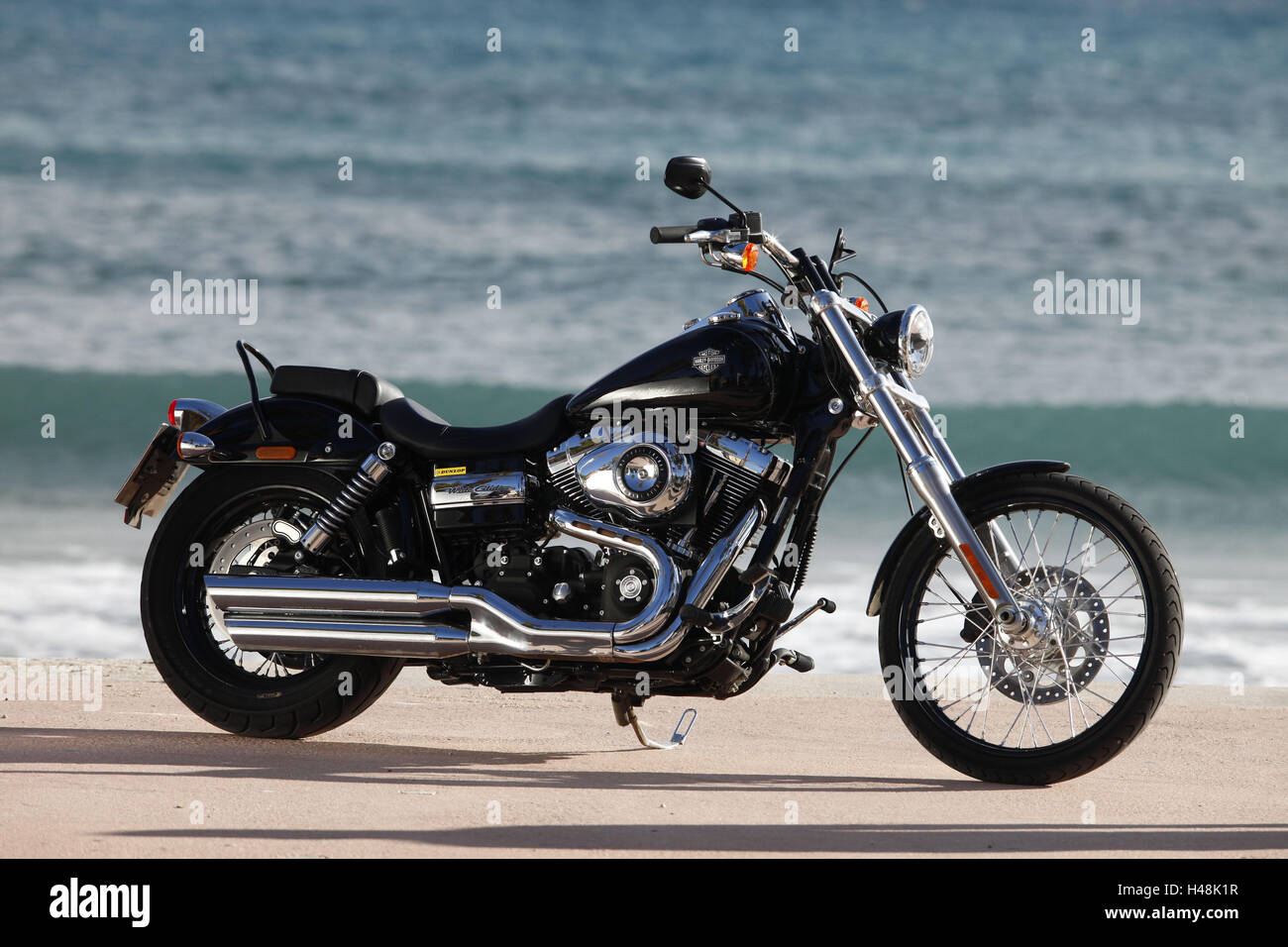 Motorrad, Cruiser, Harley Davidson Wide Glide, schwarz, Meer im Hintergrund, Seite standard rechts, Stockfoto
