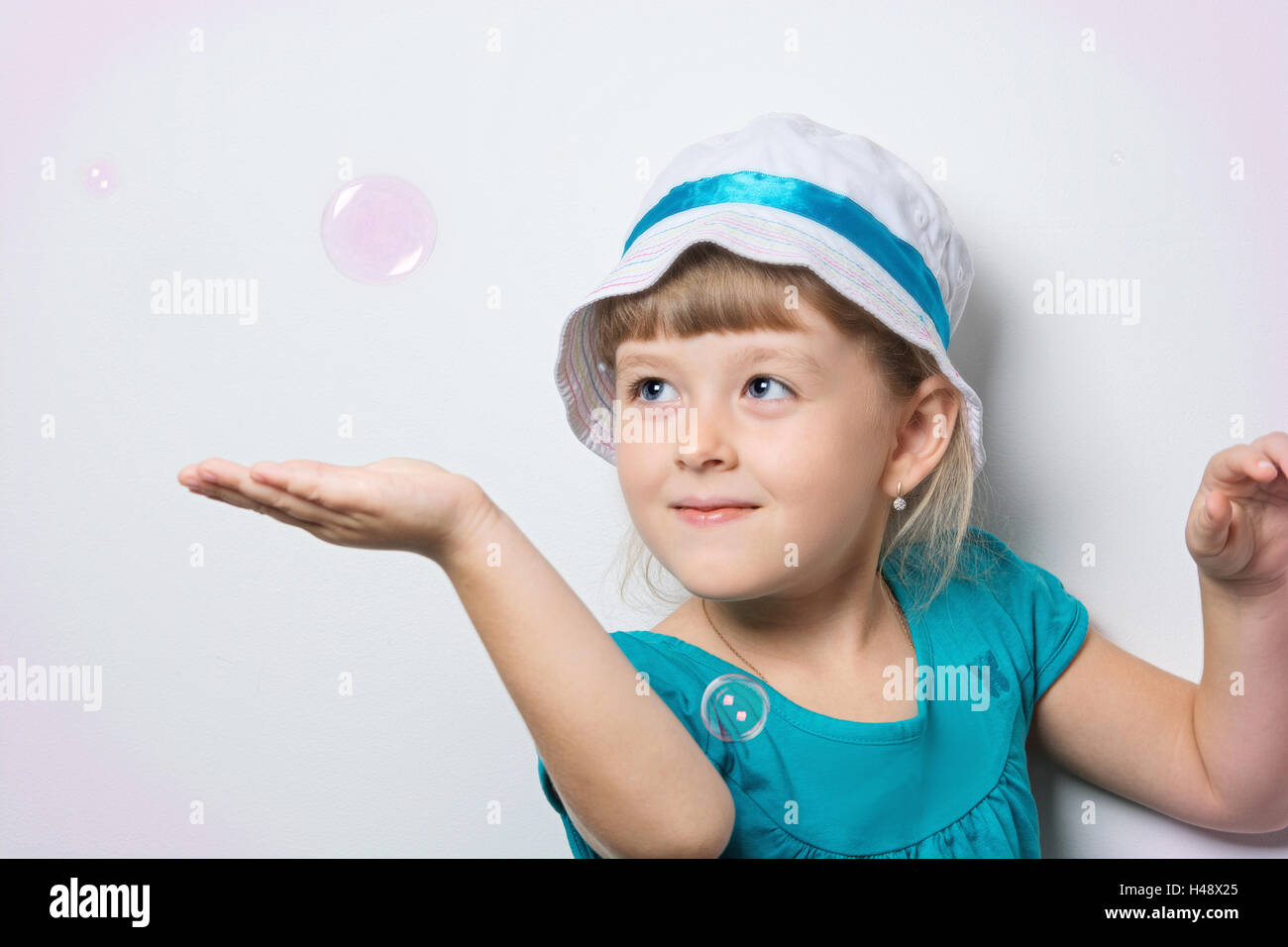 niedliche Mädchen spielt mit Seifenblasen Stockfoto