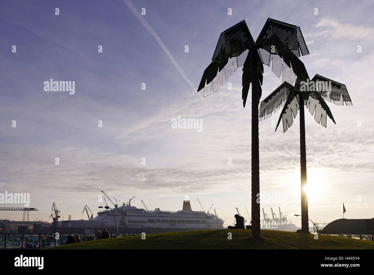 Stahl-Palmen vor Hafenkrane, Silhouetten, Hintergrundbeleuchtung, Park Fiction, St. Pauli, Hanse Stadt Hamburg, Deutschland, Stockfoto
