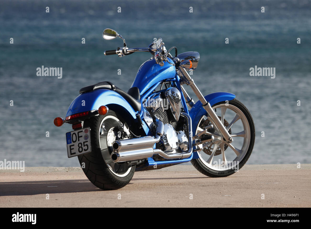 Motorrad, Honda, Cruiser, blau, Meer im Hintergrund, schräg von hinten, Stockfoto