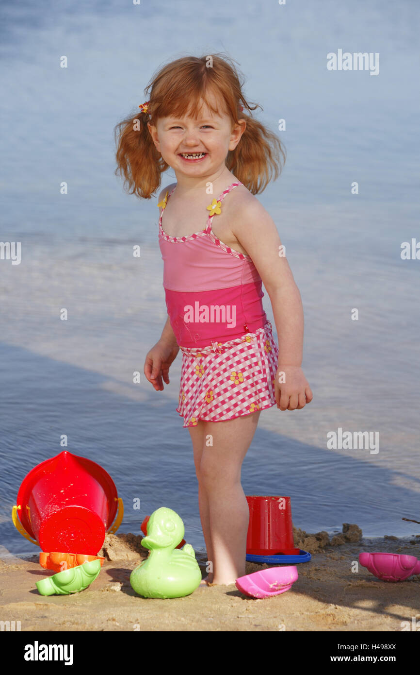 Mädchen spielt am Strand, Stockfoto